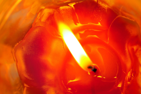 vela encendida con cera derritiéndose sobre superficie