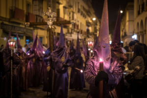 Nazareno sujetando una vela durante una procesión de Semana Santa