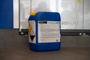 Aplicación de producto desmanchante sobre mancha en prenda Productos de lavandería profesional / blanqueantes